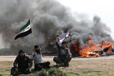 Syrians block the main highway in Neyrab in protest at the agreement on joint Turkish and Russian patrols in northwest Syria. AP