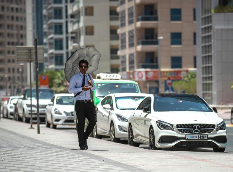 Dubai, U.A.E., June 11,2018.
Extreme warm weather at the Dubai Marina area.   A pedestrian uses an umbrella to shield himself from the sun.
Victor Besa / The National
Section:  National