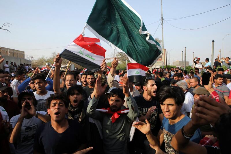 Iraqi protesters wave national flags in front of the provincial council building during a demonstration demanding better public services and jobs, in Basra, 340 miles (550 km) southeast of Baghdad, Iraq, Friday, July 27, 2018. (AP Photo/Nabil al-Jurani)