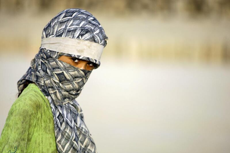 An Iraqi woman looks on as she works at a brick factory near the central Iraqi shrine city of Najaf. Haider Hamdani / AFP