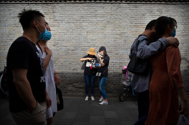People walk along a pedestrian shopping street in Beijing, China. AP Photo