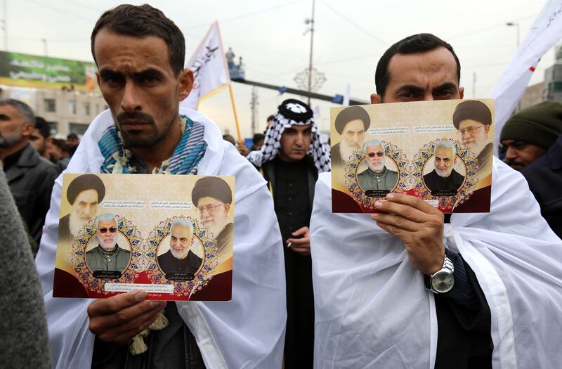PMF followers at the rally carry pictures featuring Iran’s supreme leader Ayatollah Ali Khamenei, his predecessor Ayatollah Khomeini, Al Muhandis and Suleimani. EPA