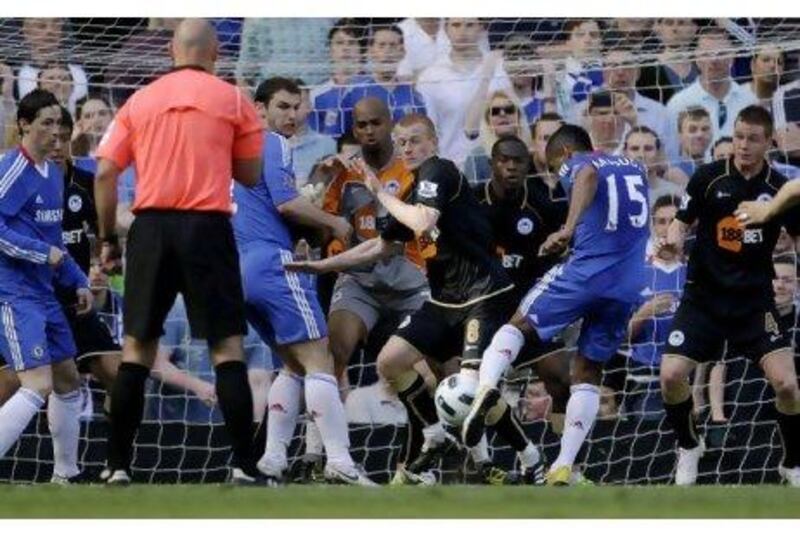 Chelsea's Florent Malouda strikes the ball to score the only goal of the game against Wigan Athletic yesterday.