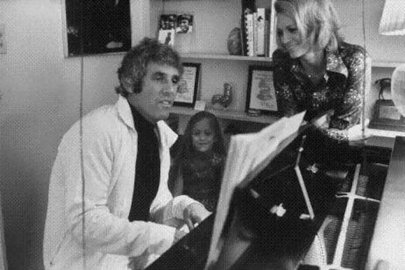 Burt Bacharach, left, plays the piano in his California home while his then-wife Angie Dickinson, right, and their daughter Nikki look on in this 1974 photo. In his recent autobiography, Bacharach and his co-writer give voice to Dickinson and his other ex-wives. John Olson / Time & Life Pictures / Getty Images