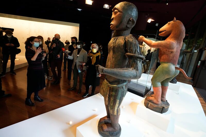 The royal statues of a half-man half-bird, left, of King Ghezo, and half-man half-lion of Benin's 19th century King Glele, are pictured at the Quai Branly–Jacques Chirac museum, Monday, Oct.  25, 2021 in Paris.  In a decision with potential ramifications across European museums, France is displaying 26 looted colonial-era artifacts for one last time before returning them home to Benin.  The wooden anthropomorphic statues, royal thrones and sacred altars were pilfered by the French army in the 19th century from Western Africa.  (AP Photo / Michel Euler)