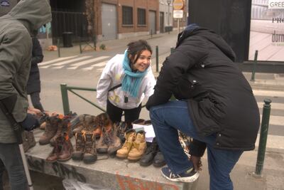Volunteer Tjara Visser distributes shoes to asylum seekers sleeping rough near the Petit Chateau reception centre in Brussels. Sunniva Rose / The National