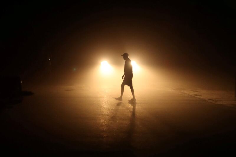 A beachgoer heads to his car long after sunset in Solana Beach following a record-setting day of temperatures according to local media, in Southern California. Mike Blake / Reuters