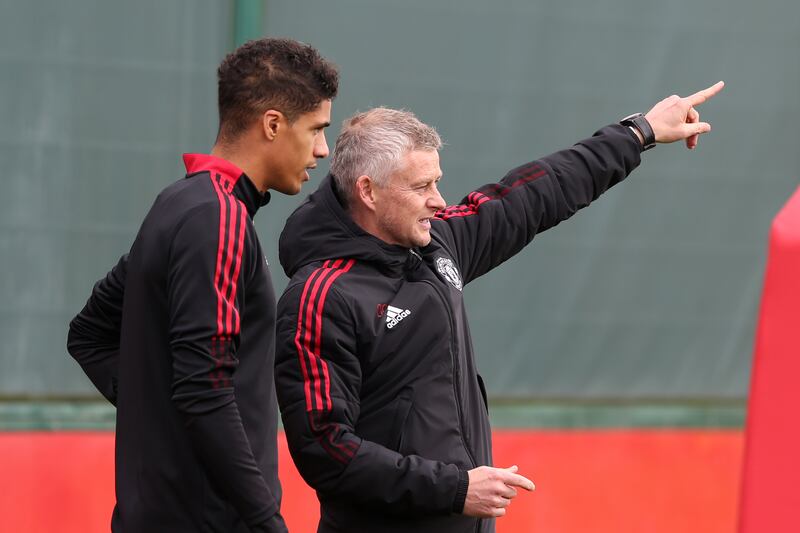Manchester United coach Ole Gunnar Solskjaer talks to Raphael Varane.