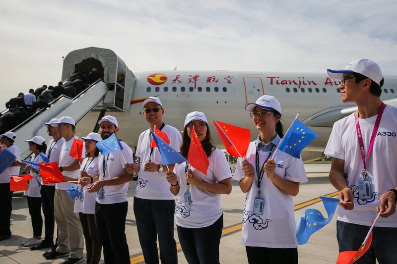 epa06214815 Visitors holding Chinese and EU flags stand next to the first Airbus A330 plane to be delivered to Tianjin Airlines during the inauguration ceremony of a A330 jets plant, in Tianjin, China, 20 September 2017. A first A330 was delivered to Tianjin Airlines to celebrate the completion and delivery centre inauguration for A330 jets. The aircraft was assembled and equipped in Toulouse, France with Chinese and European staff. The A330 is the most popular wide-body aircraft in China operated by nine airlines.  EPA/ROMAN PILIPEY