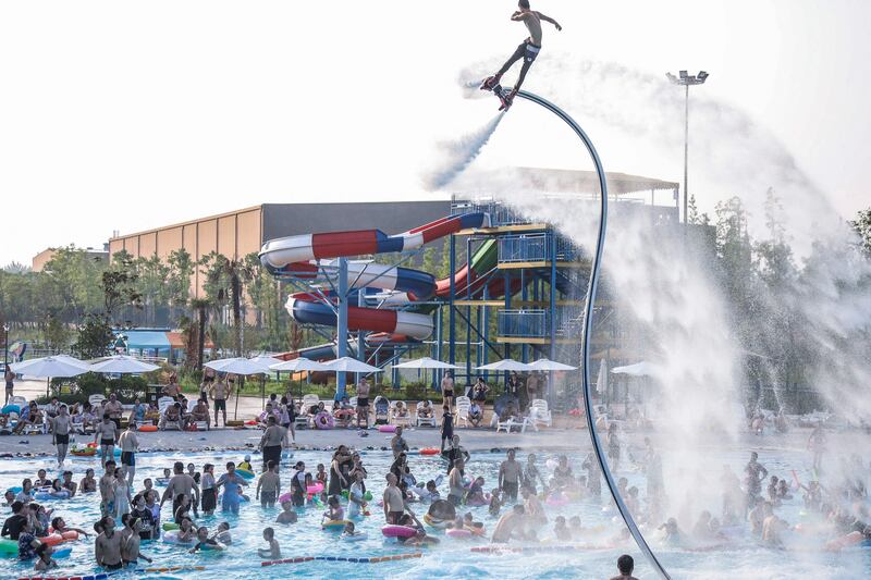 People watch a flyboard performance as they cool off in a pool to escape the hot weather at a water park in Huaian, in China's eastern Jiangsu province. AFP