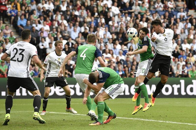 Germany's Sami Khedira, right, jumps for the ball with Northern Ireland's Craig Cathcart during the Euro 2016 Group C soccer match between Northern Ireland and Germany at the Parc des Princes stadium in Paris, France, Tuesday, June 21, 2016. (AP Photo/Martin Meissner)