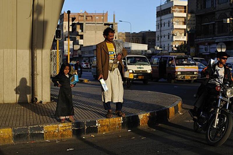 Hamas Hajiri 8, and her father Khalid sell tissues to passing drivers at an intersection in downtown Sana'a. Photo: Lindsay Mackenzie for the National.