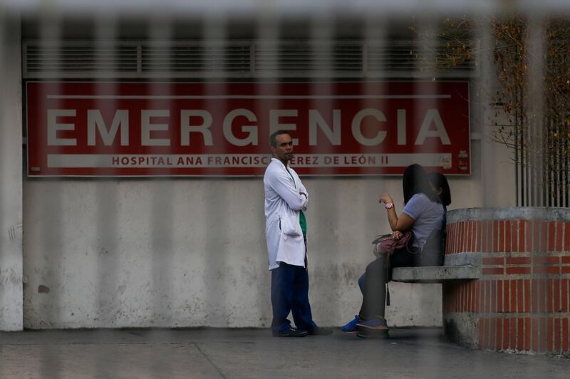 A doctor stands outside the Ana Francisca Perez de Leon hospital in Caracas on March 8, 2019 during the worst power outage in Venezuela's history. Venezuela was plunged into darkness on Thursday after a massive electricity blackout paralyzed almost the entire country. / AFP / Cristian HERNANDEZ
