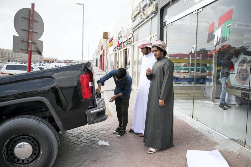 ABU DHABI, UNITED ARAB EMIRATES - NOVEMBER 27, 2018. 

Obaid Al Mansoori, 17, right, and his friend Ahmed Al Marzooqi, 17, at Grand Plus Auto Accessories, are looking for National Day decorations for their car.

They have just returned from school, where they were presenting their gyr shaheen falcon in the classroom. 

Car accessory shops in Mussafah are keeping busy as motorists rush to dress up their vehicles ahead of the UAE's 47th National Day.

(Photo by Reem Mohammed/The National)

Reporter:  HANEEN DAJANI
Section:  NA