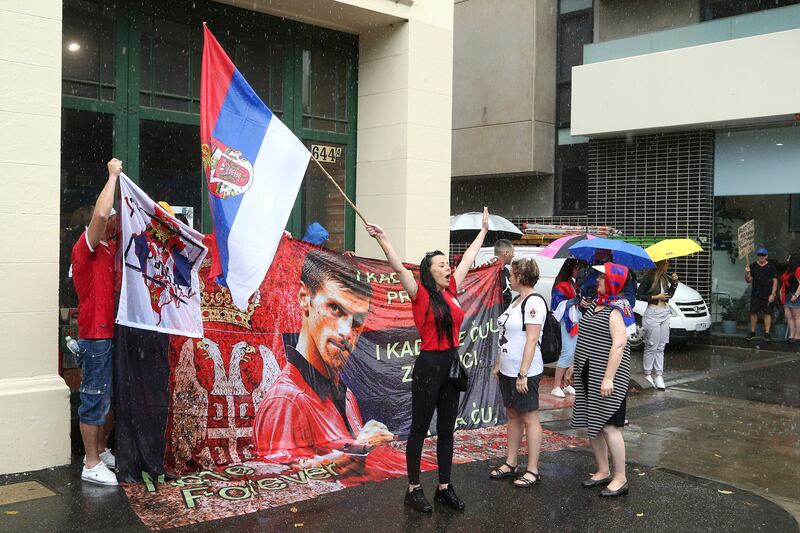 Protestors gather outside an immigration detention hotel where Serbia's Novak Djokovic is believed to stay, in Melbourne, Australia. AP Photo