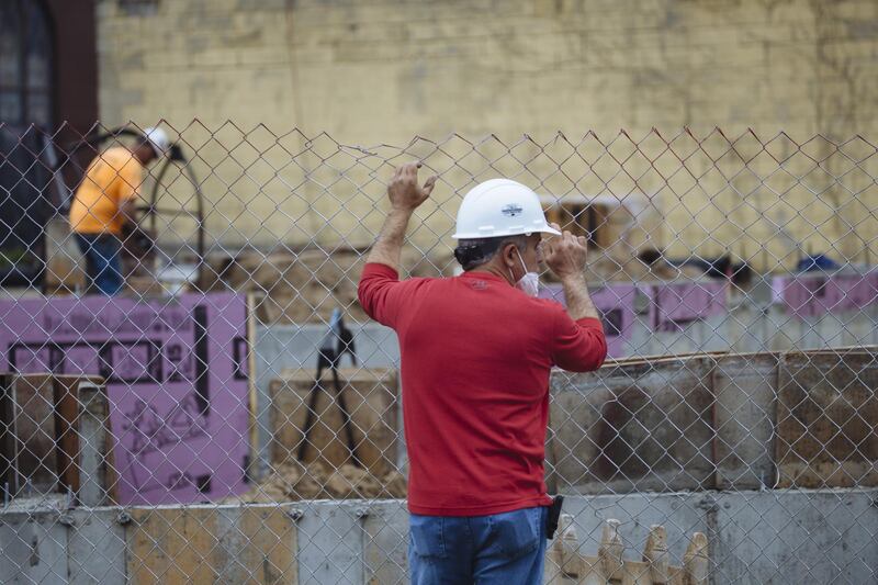 A worker holds on to a fence at a low-income housing construction site in Schenectady, New York, U.S., on Friday, May 15, 2020. With the spread of coronavirus slowing in New York, Governor Andrew Cuomo said Monday the state economy is ready to begin reopening, with some regions authorized to do so as soon as this week. Photographer: Angus Mordant/Bloomberg