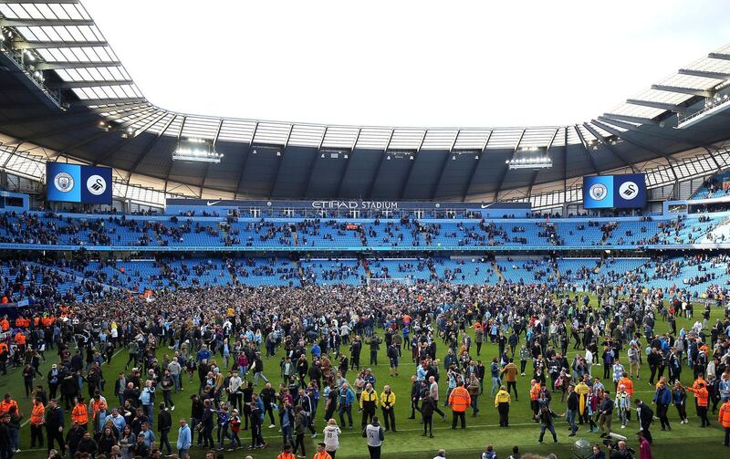 Manchester City fans invade the pitch after winning the English Premier League soccer match between Manchester City and Swansea City 5-0 at Etihad stadium in Manchester, England, Sunday, April 22, 2018. (Nigel French/PA via AP)