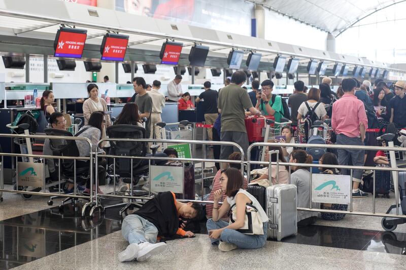 Travellers queue and wait in front of check-in counters at Hong Kong International Airport. Bloomberg