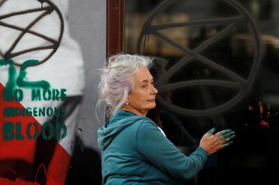 An activist paints on the embassy's facade during Extinction Rebellion climate change protest in front of Brazilian Embassy in London, Britain, August 13, 2019. REUTERS/Peter Nicholls