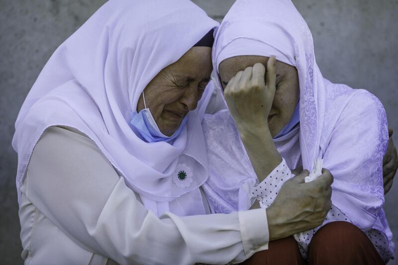 A daughter of a victim of Srebrenica genocide is hugged by her mother after seeing a coffin with remains of her father. Getty Images)