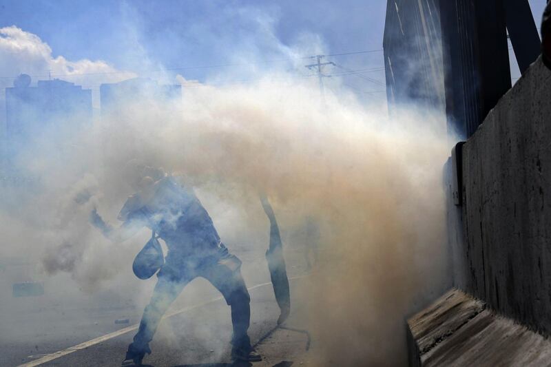An opposition demonstrator clashes with soldiers loyal to Mr Maduro. AFP