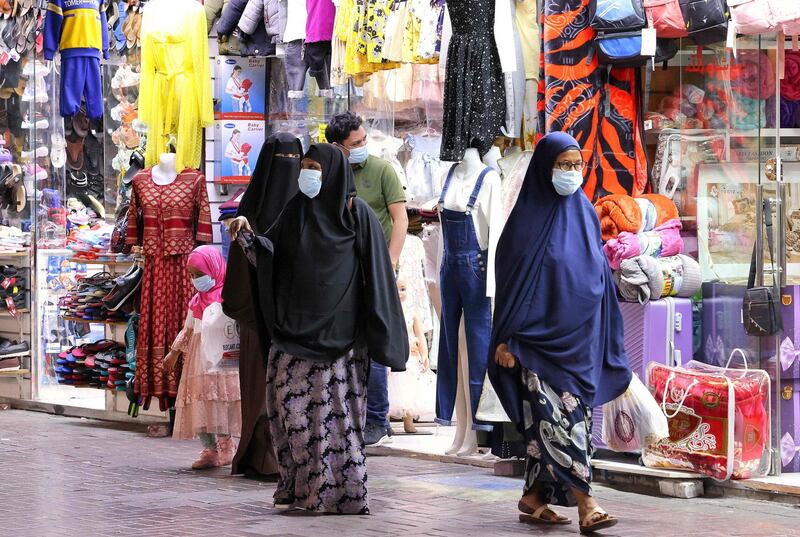 Shoppers walk outside stores in Dubai on May 5, 2021 after it opened following the breaking of the fast during the Muslim holy fasting month of Ramadan.  / AFP / Karim SAHIB
