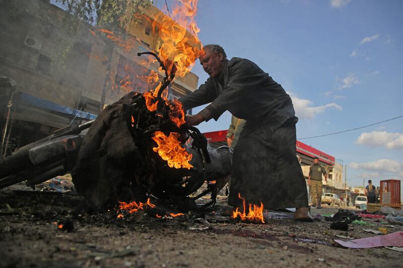 A Syrian man stands next to a burning motorcycle at the site of a car bomb explosion in the northern Syrian Kurdish town of Tal Abyad. AFP