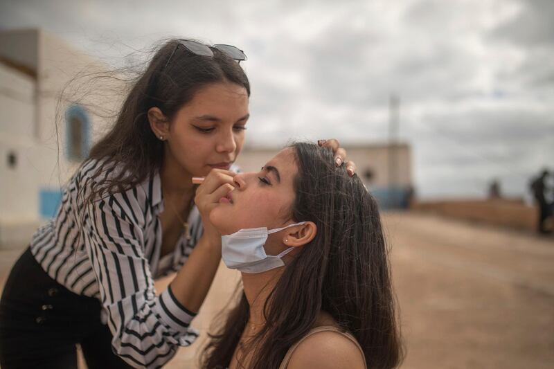 Yasmin, left, applies makeup to her friend, Mariam, as they spend time outdoors for the first time since lockdown measures were lifted, in Rabat, Morocco. AP Photo