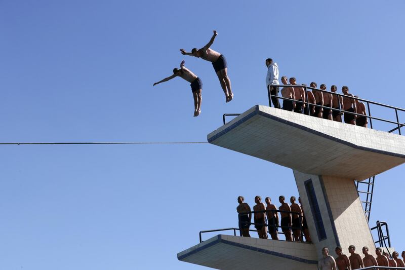 Egyptian police cadets dive into a pool.