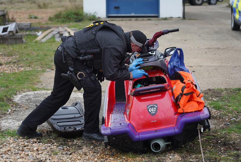 A police officer inspects the vehicle. PA