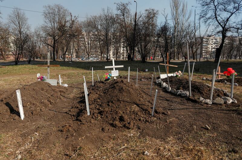 Graves of residents killed by shelling during the Ukraine-Russia conflict are seen in a yard, in the besieged southern port of Mariupol, Ukraine. Reuters