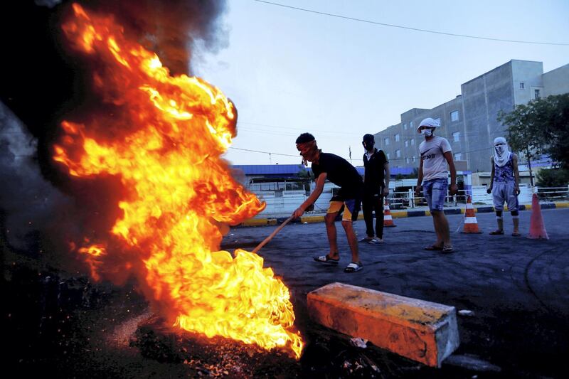 Iraqi demonstrators burn tires to block the road during a protest over poor public services in the holy city of Najaf, Iraq July 26, 2020. REUTERS/Alaa Al-Marjani