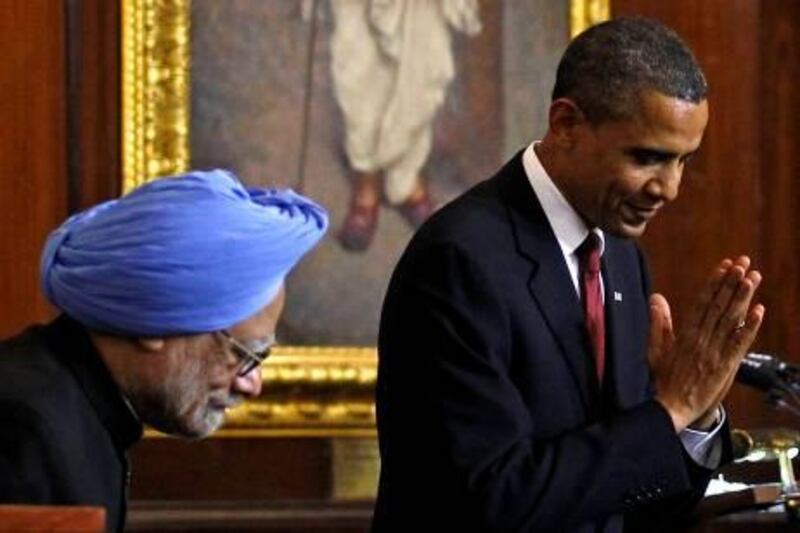 U.S. President Barack Obama, right, bows as he makes a greeting to the audience beside India's Prime Minister Manmohan Singh after delivering a speech at Parliament House in New Delhi, on Monday November 8, 2010.  (AP Photo/Jim Young, Pool) *** Local Caption ***  TOK207_India_Obama_Asia.jpg