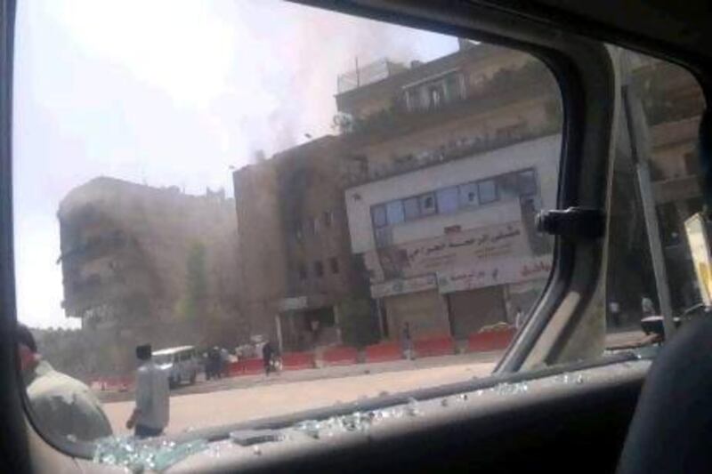 This citizen journalist image shot through a broken car window shows smoke billowing from a building after fighting between rebels and Syrian troops in the Yarmouk camp for Palestinian refugees in Damascus.