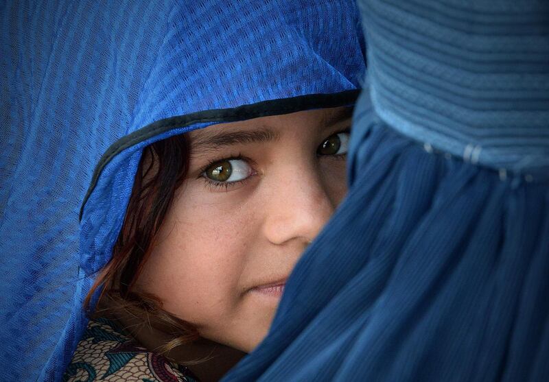 An Afghan woman carries her daughter at the Azakhel Voluntary Repatriation Centre in Nowshera. AFP