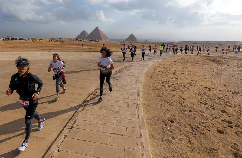 Participants run around Egypt's ancient pyramids during a half marathon in Giza, Egypt. Reuters