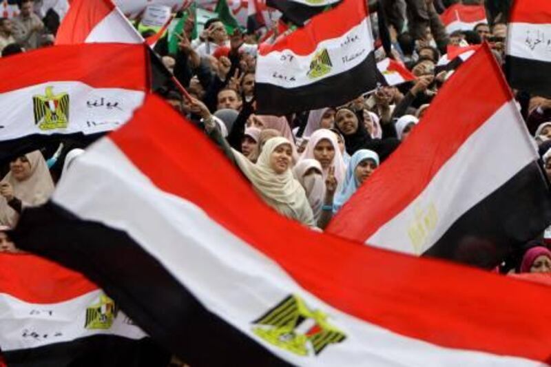 Egyptian women wave flags during a rally in Cairo's Tahrir square, Egypt, Friday, Nov.18, 2011,  in a protest against what they say are attempts by the country's military rulers to reinforce their powers.  The rally Friday was dominated by the country's most organized political group, the Muslim Brotherhood. It was called to protest a document floated by the government which declares the military the guardian of "constitutional legitimacy," suggesting the armed forces could have the final word on major policies.  (AP Photo/Amr Nabil) *** Local Caption ***  APTOPIX Mideast Egypt.JPEG-01032.jpg