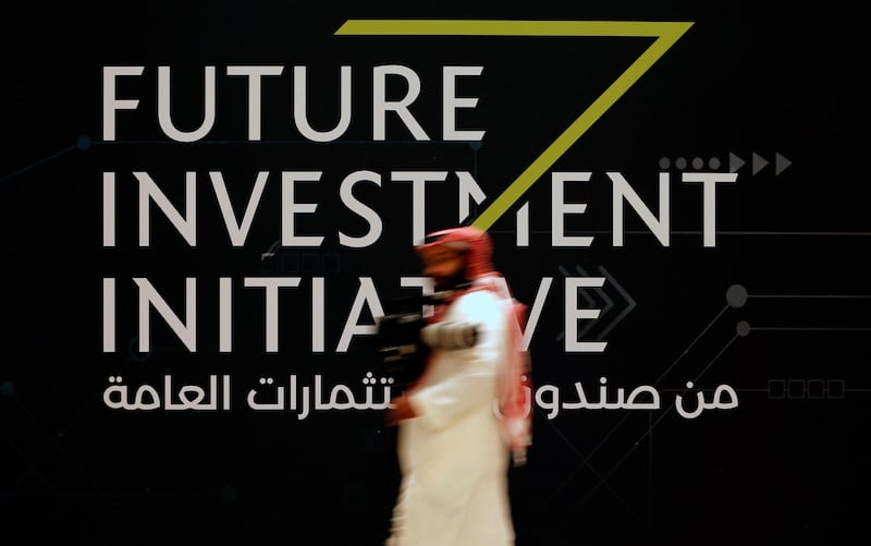 A man walks past a sign at the Future Investment Initiative conference in Riyadh, Saudi Arabia on October 24, 2017. Hamad I Mohammed / Reuters