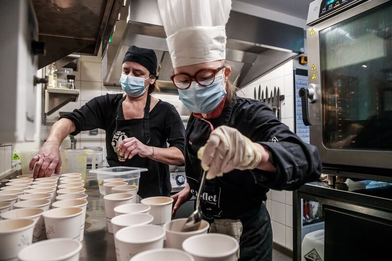 Employees at Le Reflet restaurant prepare takeaway meals for students, in Paris. EPA