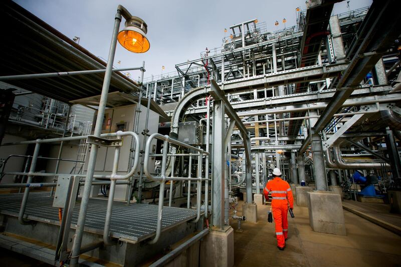 A worker walks through the Curtis Island liquefied natural gas (LNG) plant, a part of the Queensland Curtis Liquefied Natural Gas (QCLNG) project site operated by QGC Pty, a unit of Royal Dutch Shell Plc, in Gladstone, Australia, on Wednesday, June 15, 2016. Gas from more than 2,500 wells travels hundreds of miles by pipeline to the project, where it's chilled and pumped into 10-story-high tanks before being loaded onto massive ships. Photographer: Patrick Hamilton/Bloomberg