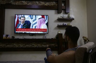 A man in Damascus watches on his television set images of Syrian President Bashar al-Assad in Jeddah on the eve of the Arab League Summit, on May 18, 2023.  Arab leaders are to welcome Syrian President Bashar al-Assad back into the fold on May 19 at the summit in Saudi Arabia that is also expected to confront conflicts in Sudan and Yemen.  (Photo by LOUAI BESHARA  /  AFP)