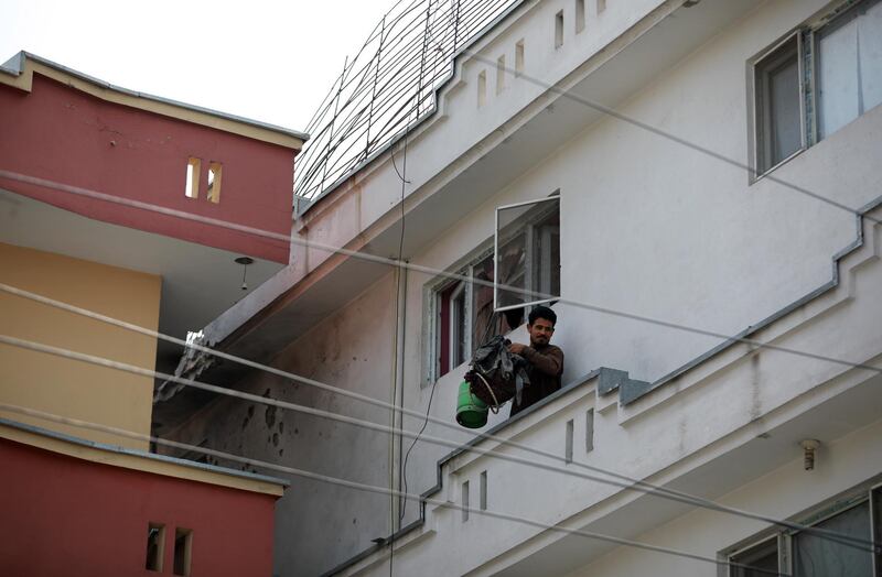 A man exits his house after its roof was hit by a rocket, in Kabul, Afghanistan.  EPA