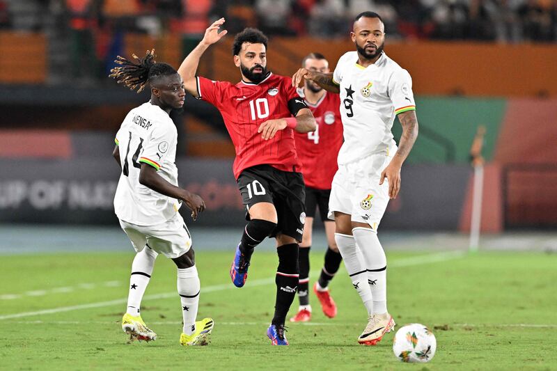 Egypt's Mohamed Salah fights for the ball with Ghana's Gideon Mensah and Jordan Ayew, right. AFP