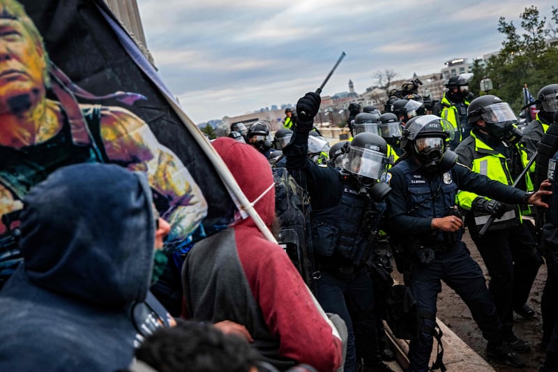 Police attempt to push the mob back. AFP