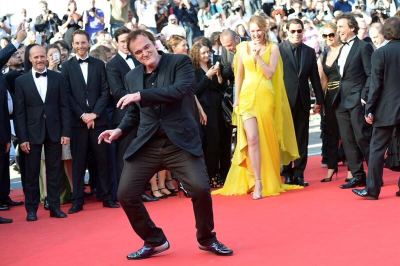 US director Quentin Tarantino dances as he arrives with US actress Uma Thurman for the screening of the film “Sils Maria” at the 67th edition of the Cannes Film Festival in Cannes, southern France. Alberto Pizzoli / AFP PHOTO 