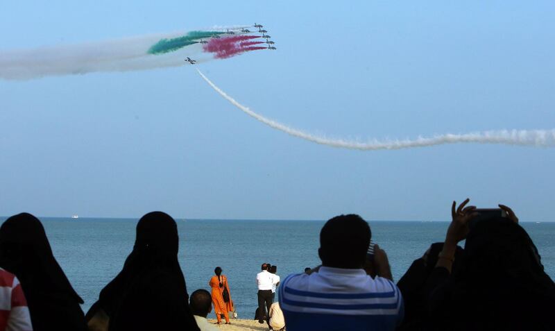 People watch as the Italian Air Force aerobatic team performs in Kuwait City. AFP