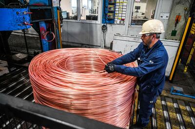An employee monitors the 8mm diameter copper cable which is rolled up before passing through a rolling mill to become cable at the Nexans manufacture in Lens, northern France. (Photo by Denis Charlet  /  AFP)
