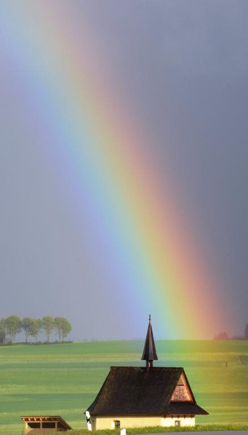 A colourful rainbow appears to touch the ground near the Weiler Chapel after the sun broke through the clouds again following a rain shower near Loeffingen, Germany. Patrick Seeger / EPA