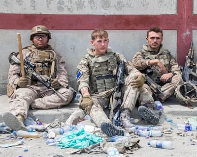 Members of the US and British Armed Forces take a break while assisting with evacuations at Kabul Airport. AFP