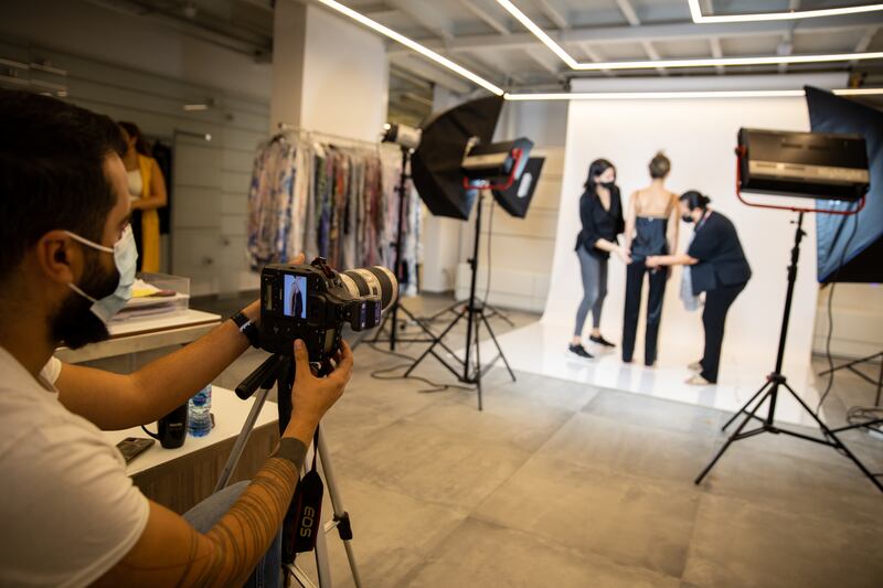Photographer Jean Saad from Parazar productions reviews images on his camera as stylists attend to a model during a Room 24 shoot at the Diamony Group.